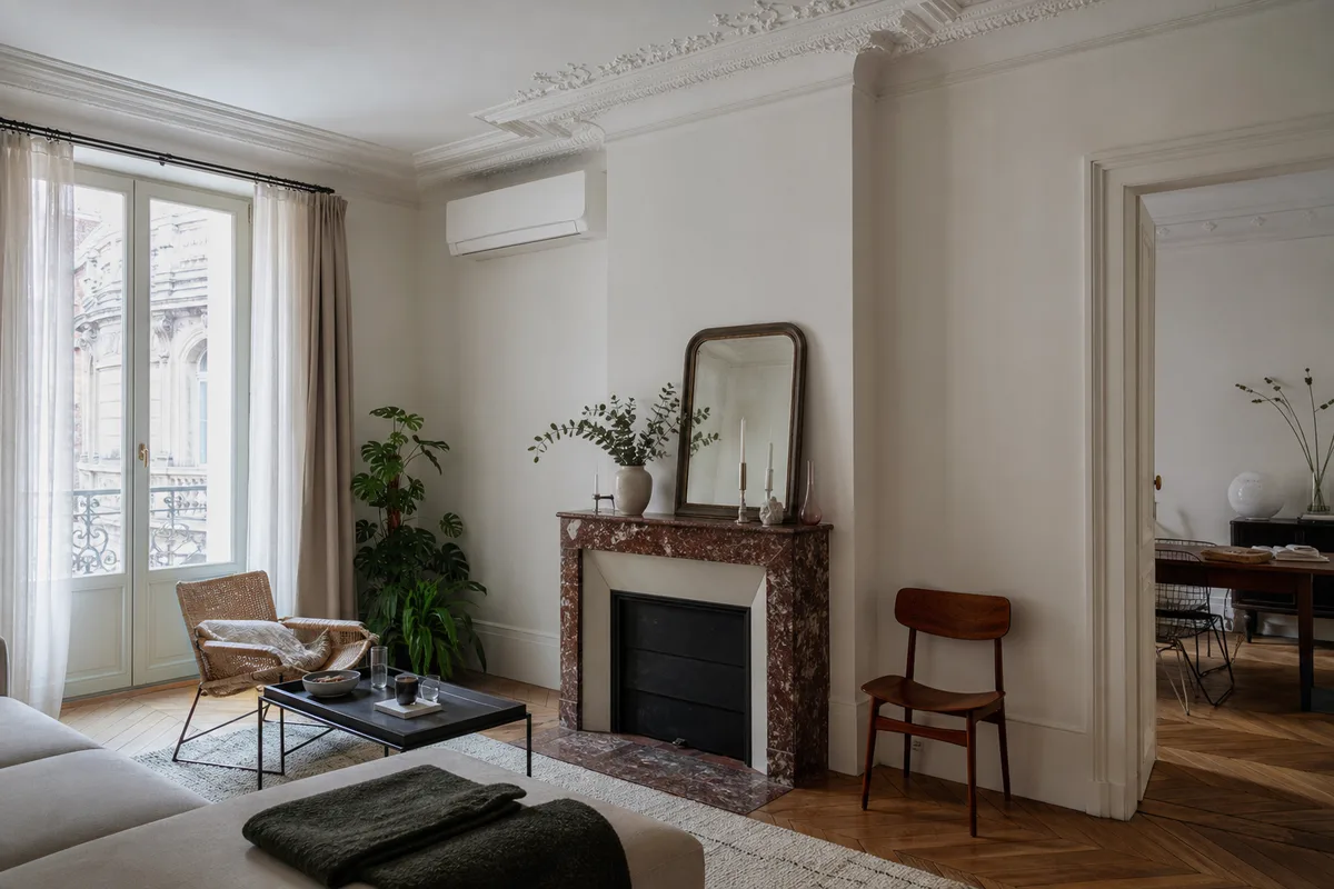 Salon lumineux d&rsquo;un appartement ancien de Strasbourg avec unité murale de climatisation réversible posée en hauteur, parquet et grande fenêtre